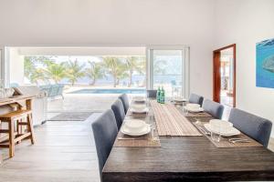 a dining room with a long wooden table and chairs at Tres Palmas Beach House in Maya Beach +34 photos