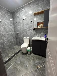a bathroom with a toilet and a sink at MMED SWEET HOMe in Bosteri