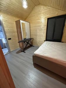 a bedroom with a bed and a table in it at MMED SWEET HOMe in Bosteri