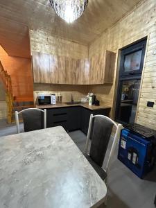 a kitchen with a table and chairs and a kitchen with a counter at MMED SWEET HOMe in Bosteri