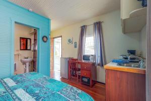 a room with a bed and a kitchen with a sink at DV #1 at DV Cabanas - Gold Standard Certified in Caye Caulker