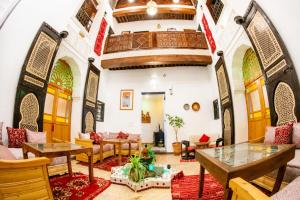 a living room with tables and chairs in a building at Riad Al Fanouss in Fez +92 photos