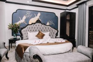 a bedroom with a large bed with a blue headboard at Crown Luxury Hotel in Hanoi +9 photos