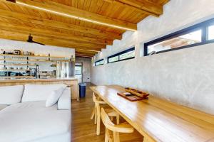 a living room with a white couch and a wooden table at Seabird - Villa 6 in Placencia