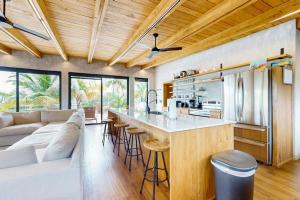 a kitchen and living room with a couch and a bar at Seabird - Villa 6 in Placencia +39 photos