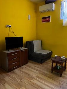a living room with a couch and a tv and a table at Cozy studio in Budva in Budva