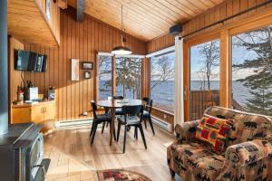 a living room with a table and chairs and windows at Lutsen Sea Villas in Lutsen