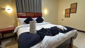 a hotel room with a bed with towels on it at The Carlisle Hotel LTD in Asaba