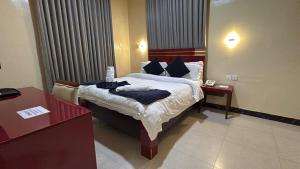 a hotel room with a bed and two tables at The Carlisle Hotel LTD in Asaba