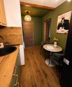 a kitchen with a table and chairs in a room at Zara Home Cozy Studio in Petroşani