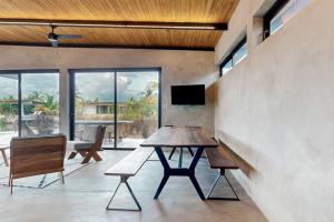 a dining room with a wooden table and benches at Seabird - Villa 26 in Placencia +39 photos