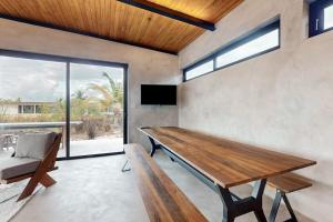 a dining room with a wooden table and a bench at Seabird - Villa 26 in Placencia