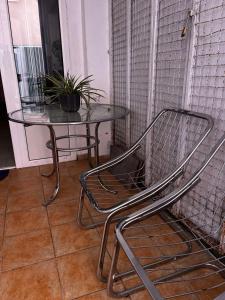 a glass table with a chair and a table with a plant at Cozy studio in Budva in Budva