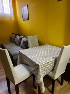 a table with chairs and a couch in a room at Cozy studio in Budva in Budva