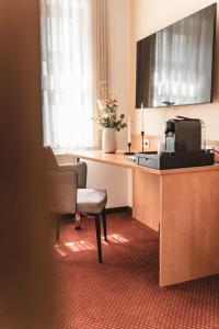 a hotel room with a desk with a computer and a chair at Filet & Freunde in Oelsnitz +5 photos