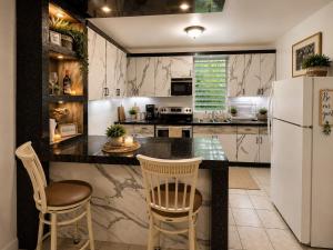 a kitchen with a white refrigerator and two chairs at Natural Village ROOM #1,2,3 & 5 in San Juan