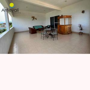 a large living room with a table and chairs at Ameyali Teques in Tequesquitengo