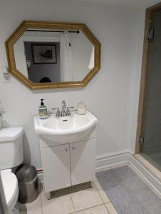 a bathroom with a white sink and a mirror at King Size In-Suite Basement in Toronto +49 photos