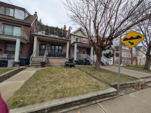 a yellow street sign in front of a house at King Size In-Suite Basement in Toronto