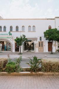 a white building with trees in front of a street at Casa Autentica 1933 in Kos