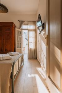 a bedroom with a bed and a tv on the wall at Casa Autentica 1933 in Kos