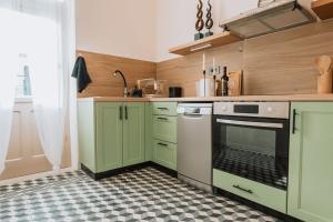 a kitchen with green cabinets and a stove at Casa Autentica 1933 in Kos