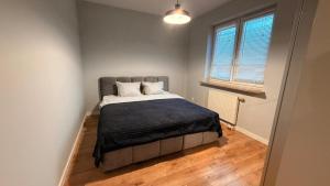 a bedroom with a bed with a blue blanket on it at Targówek Home in Warsaw