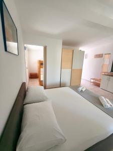 a large white bed in a room at Apartments Šešo C in Pag