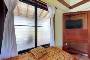 a bedroom with a window and a bed and a television at Condo #22 @ Beachside Villas in Seine Bight Village +24 photos