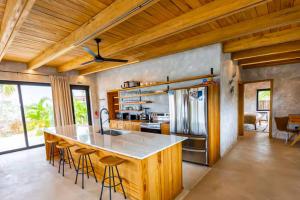 a kitchen with a large island with bar stools at Seabird Villa 11 in Placencia