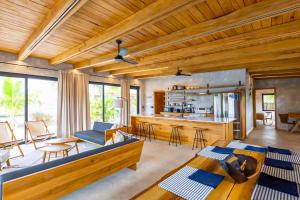 a living room with wooden ceilings and a kitchen at Seabird Villa 11 in Placencia +23 photos