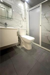 a bathroom with a toilet and a sink and a tub at Palm Dorms in Beirut