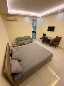 a bedroom with a bed and a couch and a table at Palm Dorms in Beirut
