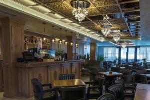 a restaurant with tables and chairs and a bar at Voko by Uka Boutique Hotel in Tirana
