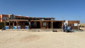 a building under construction in a desert with a blue truck at Chez Cat & Lolo in Quseir