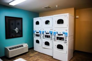 a room with four washer and dryer machines at MainStay Suites Chicago Hillside in Hillside