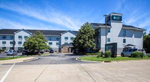 a large building with a parking lot in front of it at MainStay Suites Chicago Hillside in Hillside