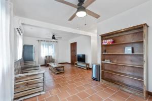 a living room with a ceiling fan and a television at Casa Edie in Placencia