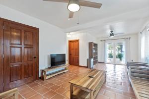 a living room with a tv and a wooden door at Casa Edie in Placencia