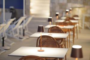 a row of tables and chairs with lamps on them at Hotel Mhami in Pulsano