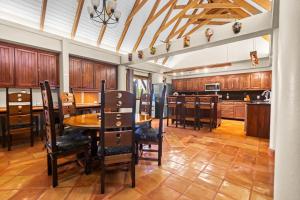 a kitchen with wooden cabinets and a table and chairs at Bougainvilla in Placencia +30 photos