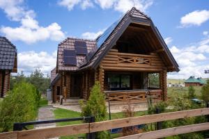 a log cabin with solar panels on the roof at Aurum Cabins in Zlatibor