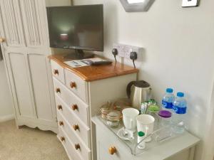 a room with a dresser with a tv on top at Stepping Stones B&B in Lymington