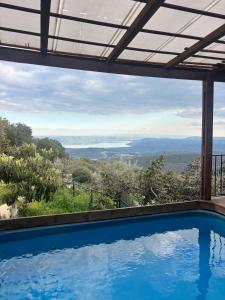 a swimming pool with a view of the ocean at Red and White אדום לבן in Amirim