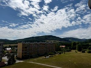 a view of a building with mountains in the background at Apartament Sudeckie Kamyki in Głuszyca