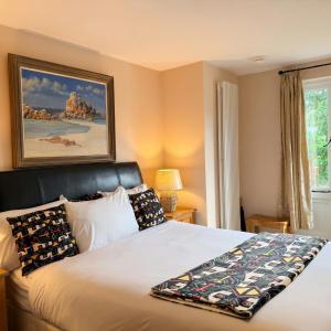 a bedroom with a bed and a picture on the wall at Potton Hall in Saxmundham