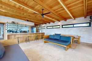 a living room with a blue couch and a bar at Seabird - Villa 1 in Placencia