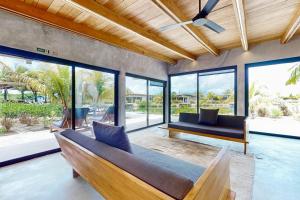 a living room with a couch and some windows at Seabird - Villa 1 in Placencia