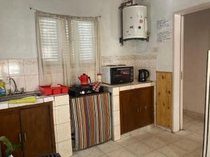a kitchen with a microwave and a stove in it at La casita in Pringles +6 photos