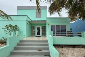 a blue house with stairs in front of it at Villa 18 at Maralaguna in San Pedro
